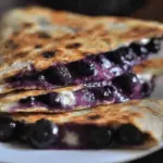 Irresistible blueberry breakfast quesadilla served with fresh blueberries and yogurt, perfect for a quick and healthy breakfast.